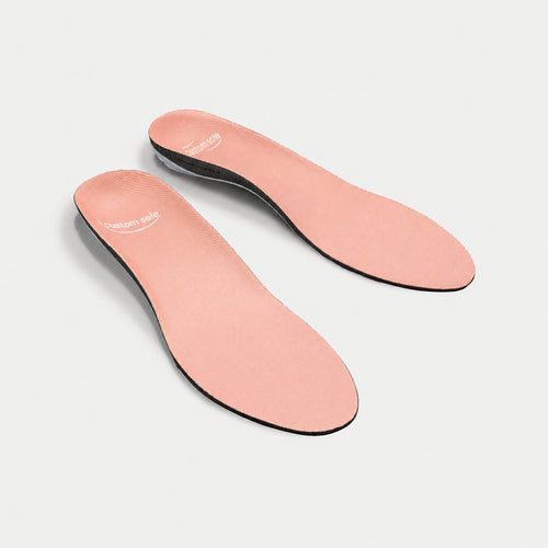Apricot custom insoles shown at an angle to reveal the contoured arch and deep heel cup