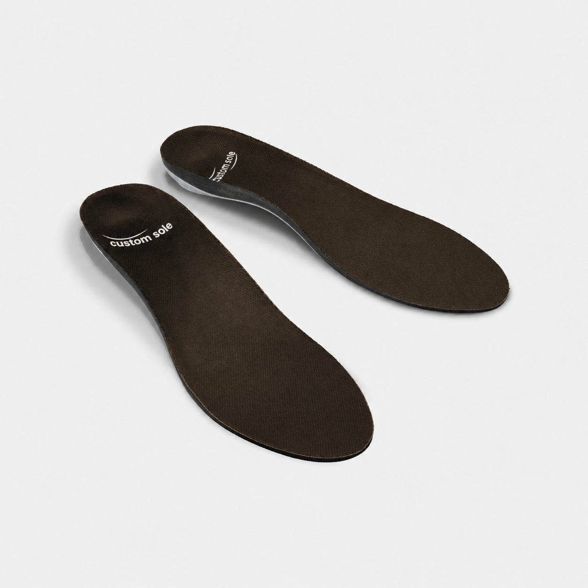 Espresso custom insoles shown at an angle to reveal the contoured arch and deep heel cup