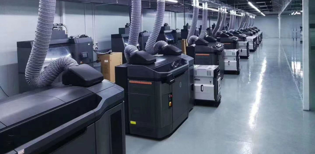 Rows of HP Multi Jet Fusion 3D printers on our manufacturing partner's production floor