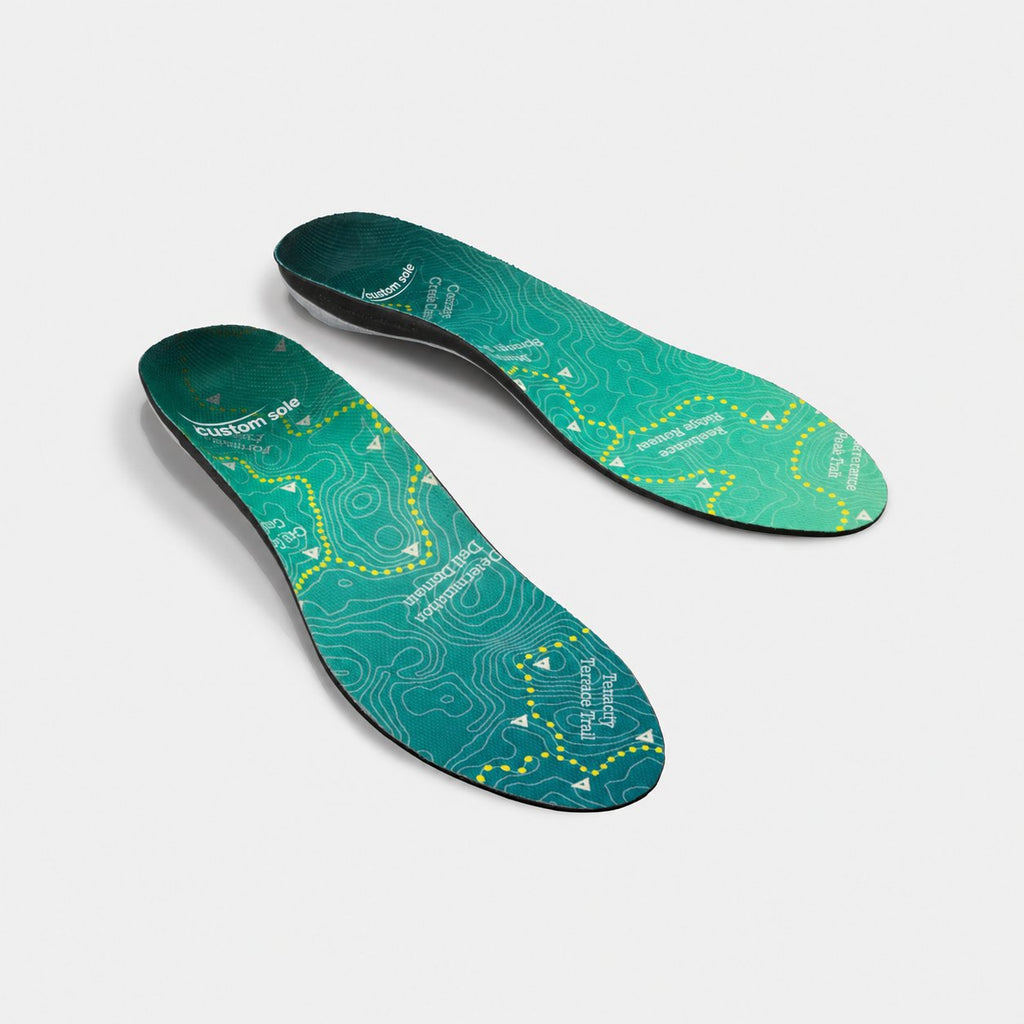 Topo Trek custom insoles shown at an angle to reveal the contoured arch and deep heel cup